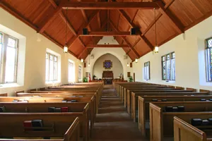 People talking and smiling in a welcoming church lobby.